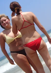 Thick girl and her skinny friend in bikinis at the beach