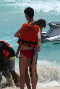 Tall sexy skinny brunette on the beach in a red bikini
