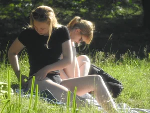 Two sexy friends in black bikinis laying out