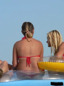 Sexy mom and daughter in red thongs at the beach