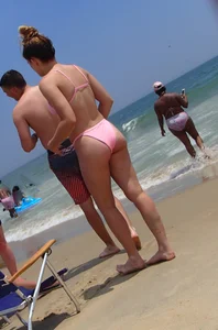 Sexy girl on the beach in a pink bikini