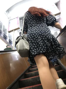 Redhead canidd milf wearing a dress on a subway escalator, hot legs
