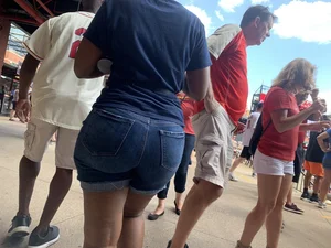 Bunch of girls in various outfits at a Cardinals baseball game