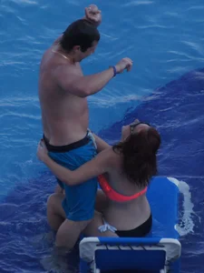 Sexy red haired girl in pink and black bikini at the pool