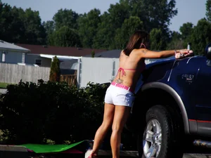 Group of cute girls at a car wash in bikinis and shorts
