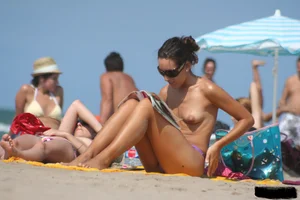 2 topless girls at the beach in thongs