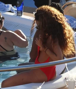 Sexy black girl in red swimsuit at the pool with side boob and a nice ass