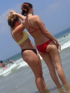 Thick girl and her skinny friend in bikinis at the beach
