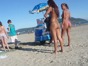 Two tattooed babes on the beach in thong bikinis with nice asses