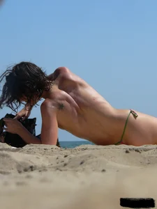 Topless beach milf looking sexy in a tiny g-string bikini