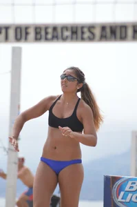 Sexy beach volleyball girl in sport bra top with pokies and blue bikini bottom
