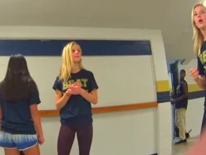 Skinny college teen in leggings bending over a drinking fountain