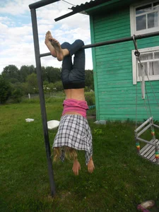 Barefoot Skinny Teen Girl Hanging Upside Down on the Countryside House Backyard