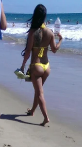 Beach babe with a nice ass and big tits in yellow thong bikini