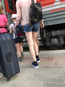 Candid with long thin legs wearing denim shorts waiting to get on a train