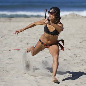 Hot girls playing beach volleyball in bikinis and shorts