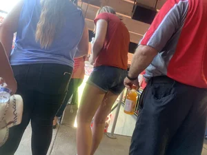 Bunch of girls in various outfits at a Cardinals baseball game