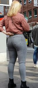Blond girl in tight grey jeans waiting for the bus