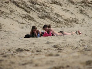 Topless beach girl with nice titties with her friend in a bikini