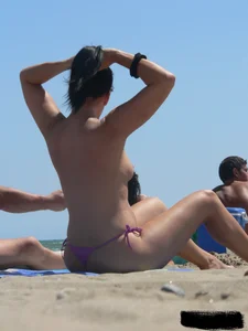 Purple thong topless lady on the beach gets oiled up by her husband