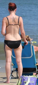 Tattooed redhead milf in a bikini at the beach