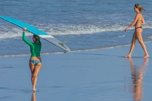 Candid girls surfing on the beach