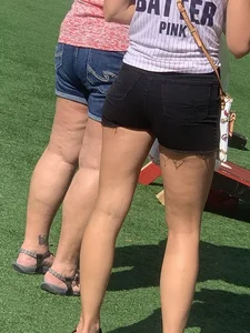 Bunch of girls in various outfits at a Cardinals baseball game