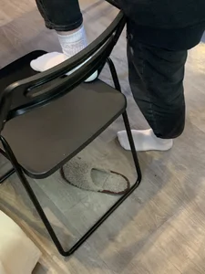 Young Skinny Girl's Legs in Black Jeans And White Socks Foot on the Chair Closeup