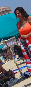 Beach girl with big boobs in an orange swimsuit
