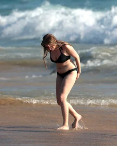 Cute bikini girl in the water in a black bikini