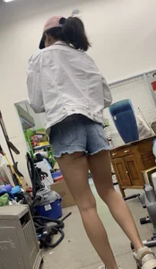 Tight bum hanging out of jean shorts in thrift shop