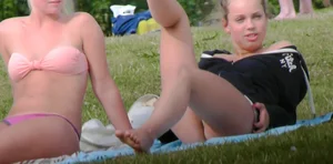 Three sexy girls in bikinis exercising at the park
