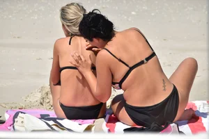 Blonde and brunette on the beach looking sexy in their bikinis