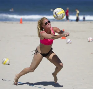 Hot girls playing beach volleyball in bikinis and shorts