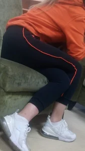 Girl in Sporting Pants And Sneakers Sitting on the Couch Creepshot