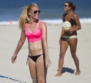 Hot girls playing beach volleyball in bikinis and shorts