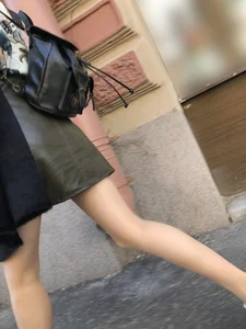 Nice slim legs of a candid girl wearing a leather skirt