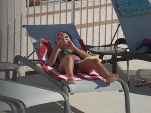 Hot milf sunbathing in a thong by pool and swimming