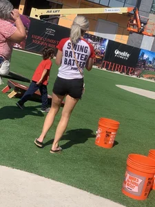 Bunch of girls in various outfits at a Cardinals baseball game