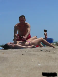 Purple thong topless lady on the beach gets oiled up by her husband