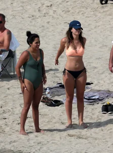 Big boobed babe with pokies in a bikini on the beach with friends