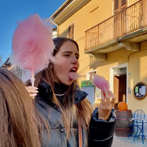 Cute Girl With Opened Mouth on the Street, Eating a Cotton Candy