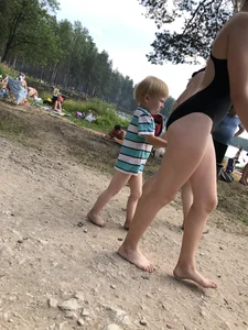 Cute Barefoot Girl in a Black Body Swimsuit Walking on a Road