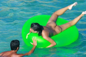 FKK Nudists playing in the water with floater