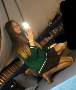 Cute young girl in a skirt and black pantyhose sitting on the floor with her shoes off