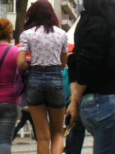 Redhead girl with her cheeks eating her denim shorts