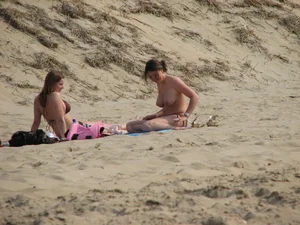 Topless beach girl with nice titties with her friend in a bikini