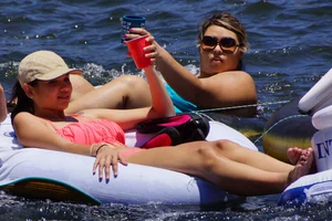 Sexy party girls in bikinis on a lake
