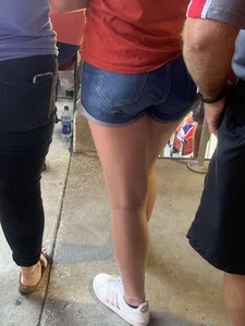 Bunch of girls in various outfits at a Cardinals baseball game