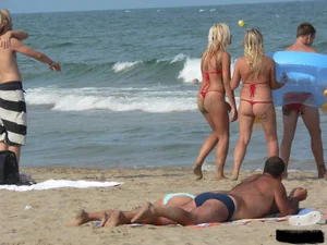 Sexy mom and daughter in red thongs at the beach